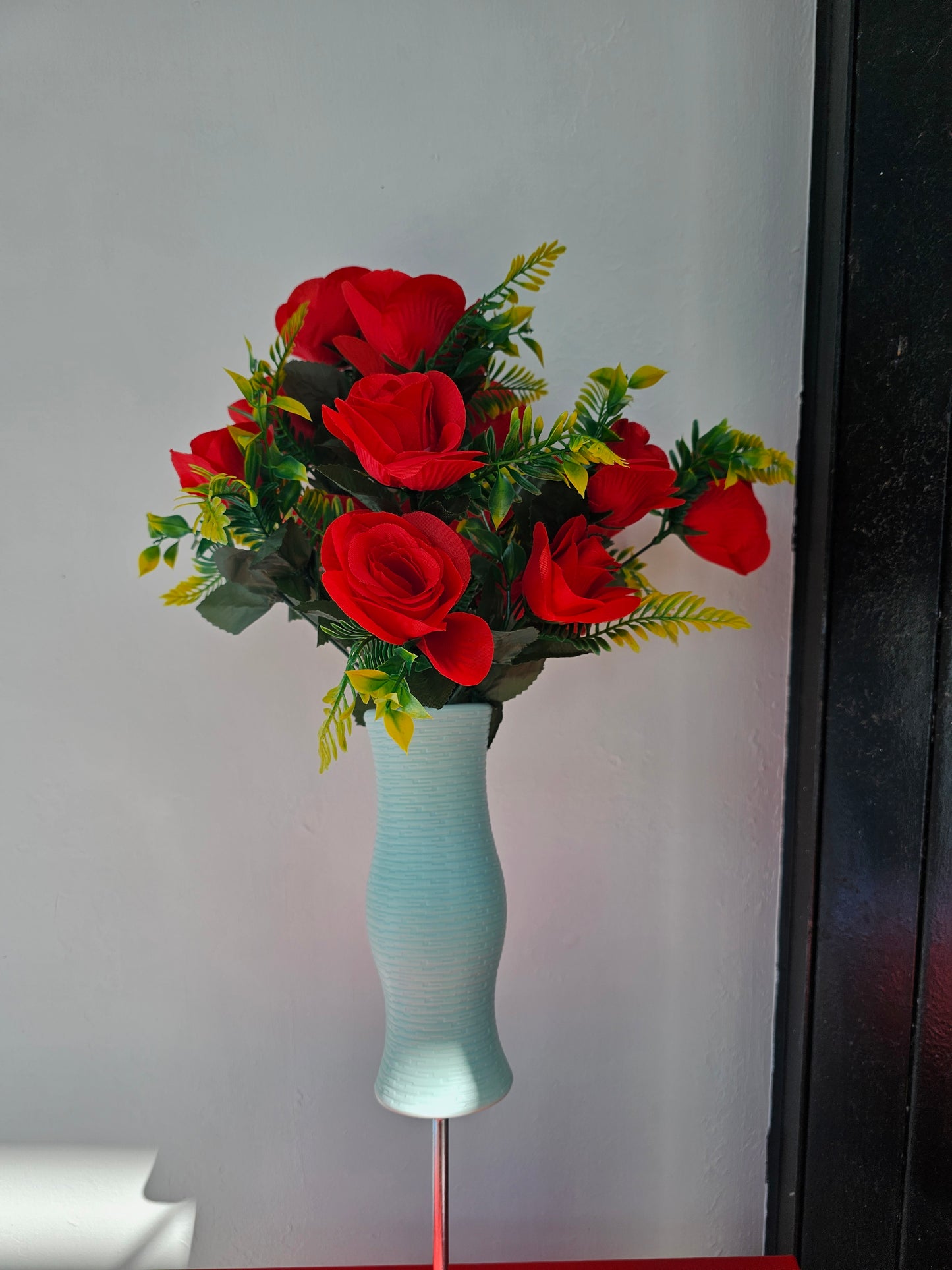 Artificial flower bouquet in vase with ground stake