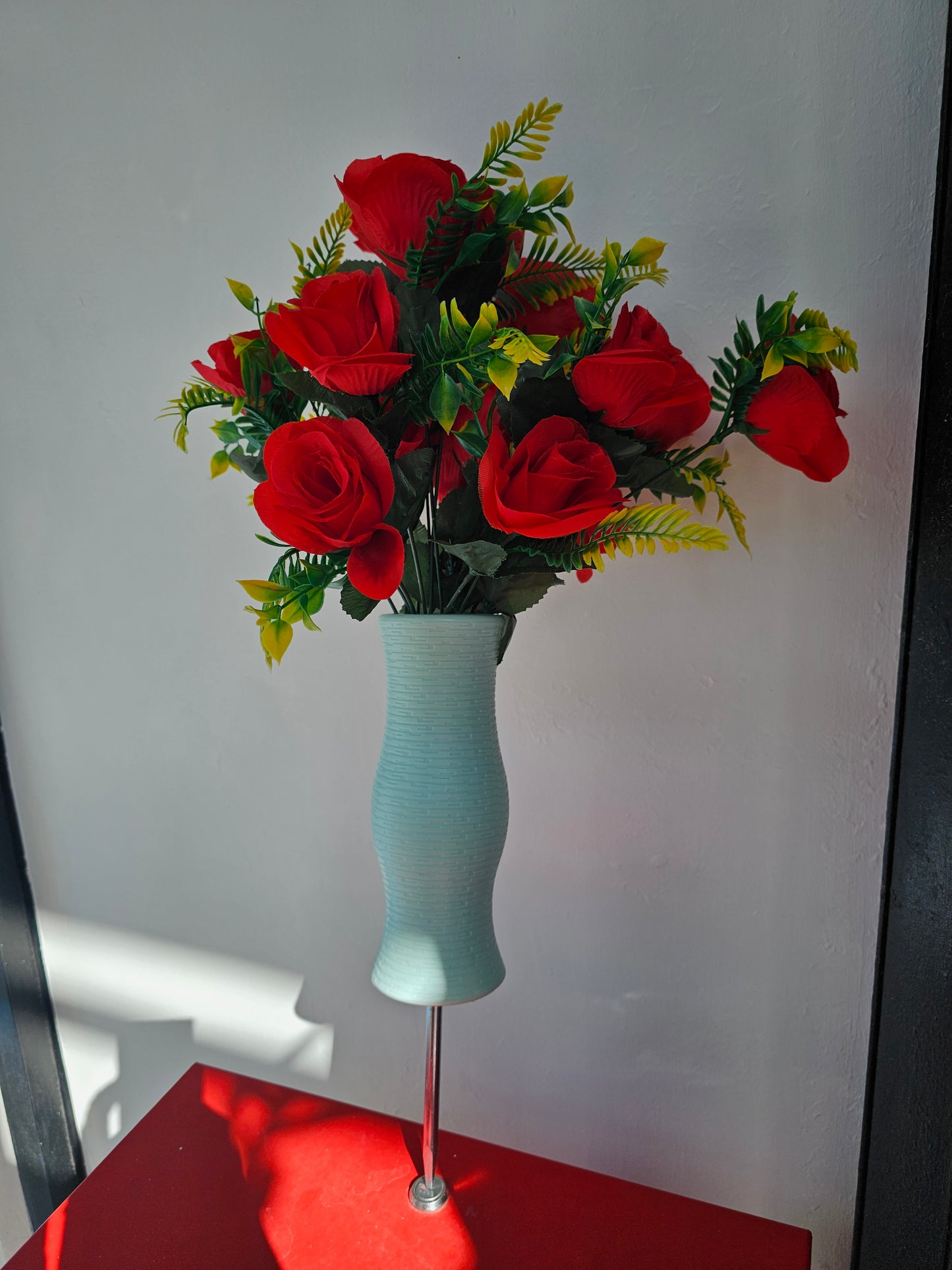 Artificial flower bouquet in vase with ground stake
