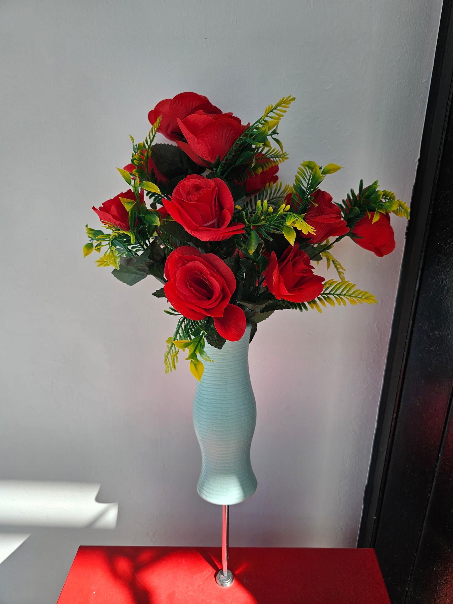 Artificial flower bouquet in vase with ground stake