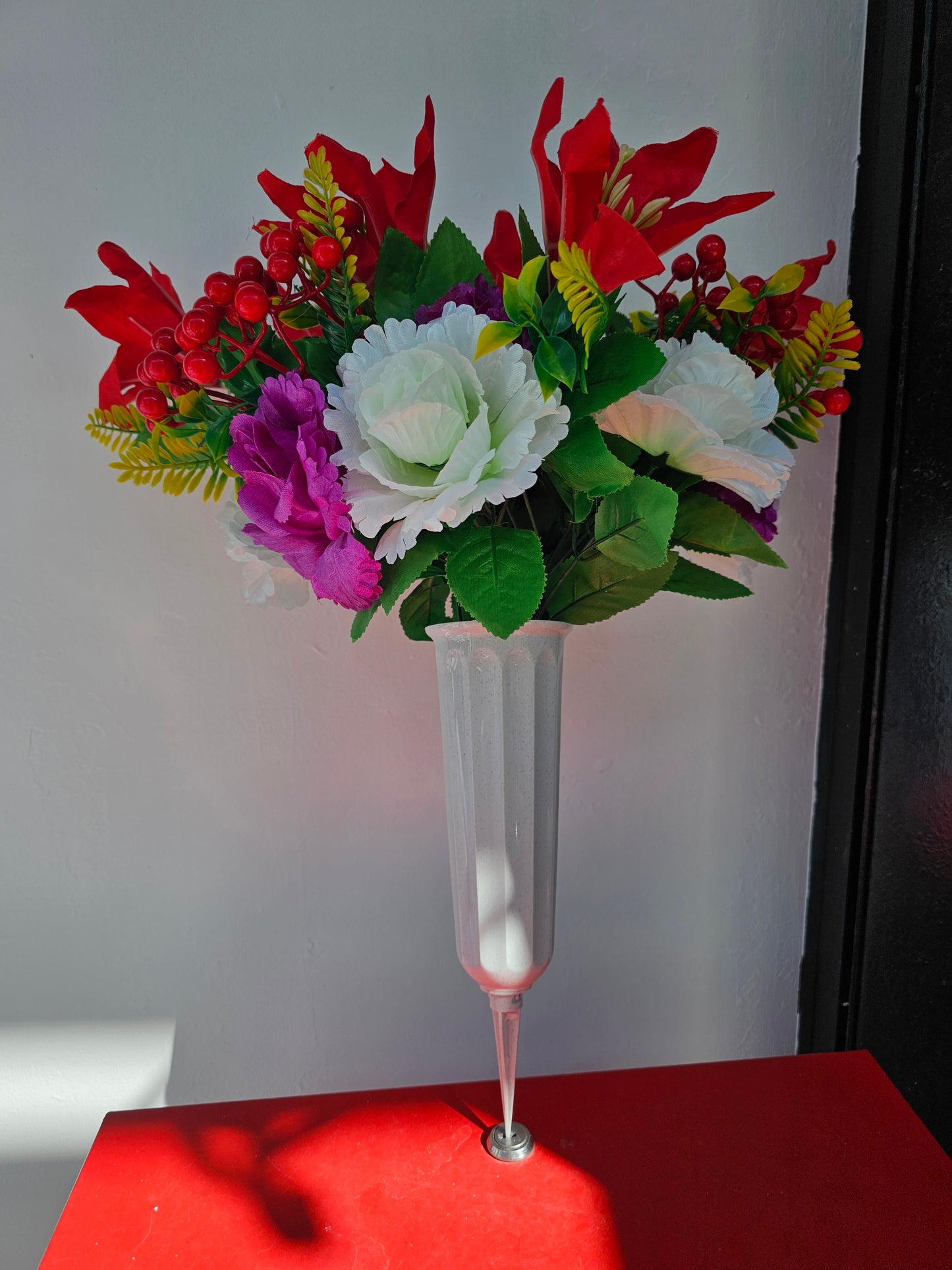 Artificial flower bouquet in vase with ground stake