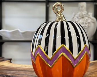 Decorative ceramic Halloween pumpkin featuring a distinct hand-painted seasonal design