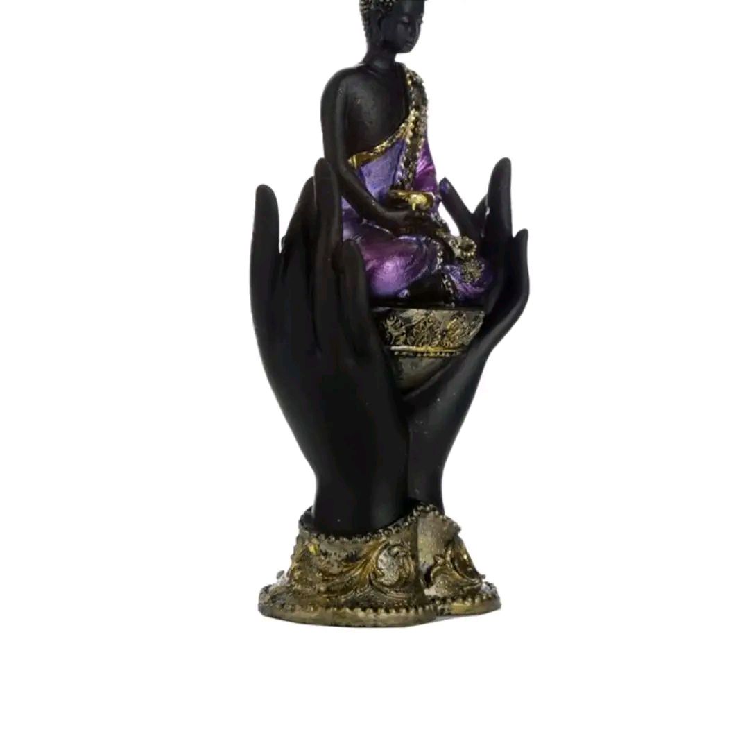 purple and gold black thai buddah sitting in hands